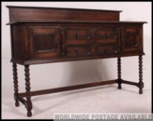 A good quality 1920's Jacobean revival oak sideboar raised on bobbin supports united by strethers
