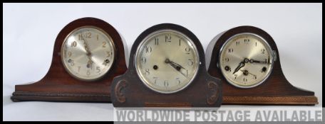A collection of three mid century mantel clocks having napoleons hat examples with silvered dials,