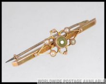 A 15ct gold and peridot set ladies bar brooch with seed pearl borders having pin to verso.