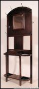 A 1920's oak hall stand having central glove drawer with mirror upright and hooks atop