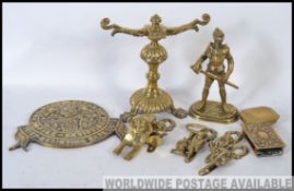 An assorted collection of brass wares to include a Milners safe plate, character door knockers,