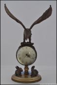 A novelty brass desk ball clock, surmounted with an eagle, the base mounted with two rabbits.