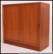 A retro teak wood 1970's Industrial office sliding door cabinet.