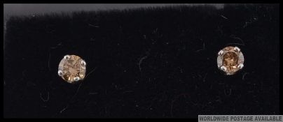A pair of 14c white gold champagne diamond stud earrings