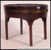 A 19th century George III mahogany coopered and brass bound oval wine cooler on stand being raised