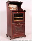 A 1920's mahogany music cabinet, with opening slots to base and plaques to top.