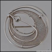 A 925 silver Art Nouveau style brooch with central tuplip form on a textured ground with roller