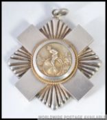 A silver medallion with central cast plaque of penny farthing cyclist being inscribed to verso '