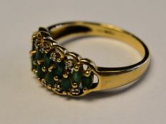 A 9ct gold and emerald ladies ring. The marquise cut emeralds being off pave set ( 12).