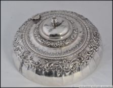 An embossed and decorative silver powder pot bearing Sheffield hallmarks for James Dixon & Sons,
