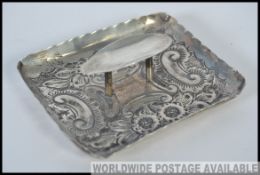 An hallmarked silver ashtray, with chase decoration, bearing worn marks W8cm 34.