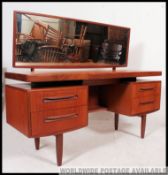 A 1970's retro teak wood G-Plan suspension set dressing table having pedestals of drawers raised