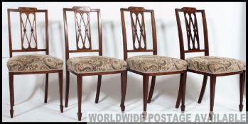 A set of 4 Edwardian marquetry inlaid lattice back dining chairs being raised on tapering legs with