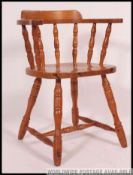 A country pine 20th century smokers bow armchair with panel seat and turned legs with spindle
