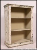 A Shabby chic painted and distressed open window bookcase cabinet with flared cornice over fixed