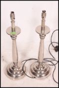 A pair of heavy quality silver plated large table lamps .