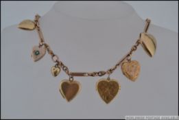 An interesting collection of 10 9ct gold heart lockets strung upon a 9ct gold watch chain one set