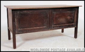 An early 20th century country oak coffer being raised on shaped supports with fielded panel body
