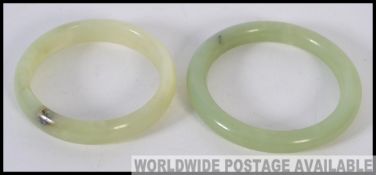An Apple Green Jade Bracelet together with a bright green jade bangle of similar form