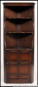 A large Ercol colonial corner cabinet having open shelving over cabinet to the base.
