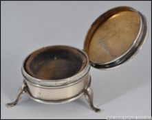 A hallmarked silver antique powder / snuff pot. Standing on three legs, with hinged top.