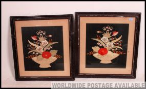 A pair of framed and glazed hand embroidered still life panels set to black fabric backgrounds.