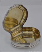 An unmarked Georgian silver snuff box of scalloped form with later 19th century engravings.