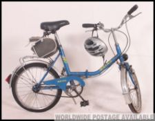A vintage 20th century folding bicycle together with helmet and dynamo