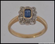 A 9ct gold sapphire and diamond ladies ring having a central rectangular cut sapphire surrounded by