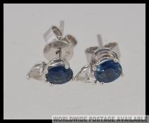 A pair of 18ct white gold diamond and sapphire earrings / studs with beautiful round cut claw