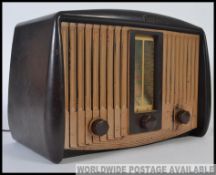 A vintage 20th century bakelite valve radio by GEC having shaped body with decorative facia