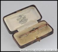 A 9ct gold peridot and seed pearl vintage ladies brooch of bar form.