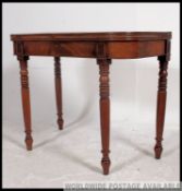 A 19th century Georgian mahogany games table / card table raised on turned legs with hinged top