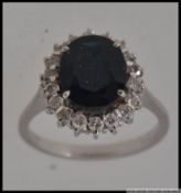 A hallmarked 750 18ct white gold ring set with a large oval cut central sapphire surrounded by a