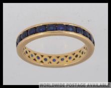 An 18ct gold and sapphire eternity ring with approx 20+ sapphires. Total weight 3.6g / Size L.