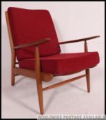 A 1970's retro Danish influence teak wood armchair in the manner of Parker Knoll having a show wood