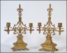 A pair of 20th century brass candlestick holders / sconces on shaped brass bases.