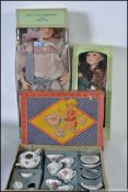 A boxed mid century childs tea service along with two boxed ceramic headed dolls
