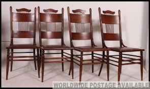 A set of four American oak shaker style bentwood dining chairs being raised on turned legs with