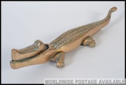 An early 20th century large cast brass nut cracker in the form of a crocodile L35cm