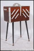 A mid century vintage / retro cantilever / metamorphic sewing box raised on tapered legs