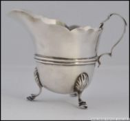 A silver hallmarked creamer, with a London assay mark, date letter for 1912, raised on hoof feet 69.
