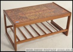 A late 20th Century rectangular teak coffee table with inset fat lava style tiled top,