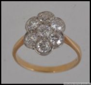 An 18ct gold and diamond ring having 7 20pt diamonds in a daisy setting. Marked 18ct. Weigth 3.2g.