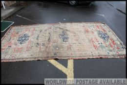 A large early 20th century handwoven Islamic / Persian rug having beige and red ground with blue
