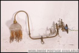 A long armed and decorative brass side wall lamp. 19th century with cut glass shade and beading.