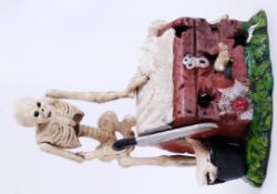 MONEY BOX: A 20th century cast iron hand painted style money box in the form of a macabre magician