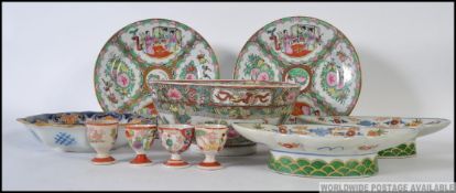 A Chinese famille rose large bowl stylised with scenic cartouche panels and foliate/geometric
