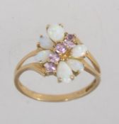 A hallmarked Birmingham 9ct gold ring with opals and pink stones in a butterfly setting with split