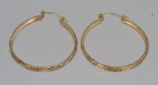 A pair of large designer hallmarked 375 9ct London gold hoop earrings with cut star decoration and